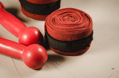 Kırmızı dumbell ve bandaj/spor kavramı kırmızı dumbell ve bir taş bandaj ile. Seçici focu