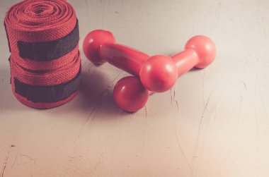 Kırmızı dumbell ve bandaj/kırmızı dumbell ve taş zemin üzerine bandaj. Tonda