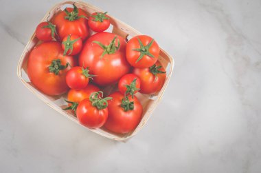 gerdanlı bir sepet beyaz mermer zemin, üstten görünüm üzerinde bir gerdanlı sepeti/domates domates