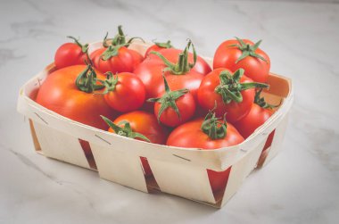 beyaz mermer zemin, seçici odak gerdanlı kapsayıcı gerdanlı bir konteyner/domates domates