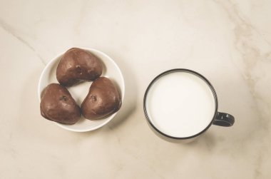 Çikolata gingerbreads ve süt/çikolata gingerbreads ve süt beyaz mermer zemin üzerinde siyah bir kupa ile kahvaltı. Üstten görünüm