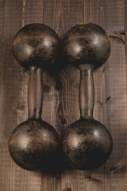 iki eski ahşap koyu arka plan üzerinde halter demir / ahşap koyu arka plan üzerinde halter iki eski demir. Üstten görünüm