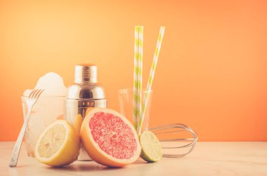 Kokteyl yapımı araçları, shaker, tropik meyveler turuncu arka plan/kokteyl alma araçları, shaker, tropik meyveler turuncu bir arka plan üzerinde bar bar. Seçici odak