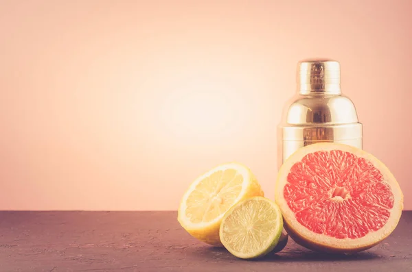 Cocktail shaker and tropical fruits on a pink background/Cocktail shaker and tropical fruits on a pink background. Selective focus and copyspac