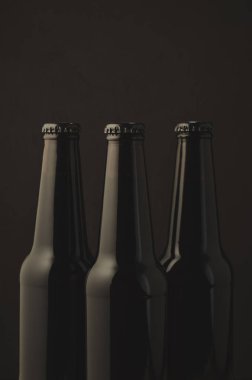Üç şişe bira karanlık bir arka plan üzerinde siyah / üç şişe bira karanlık bir arka plan, seçici odak üzerinde siyah