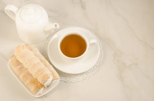 tea drinking with cream cakes/ tea drinking with cream cakes on a white table. Top view and copy space