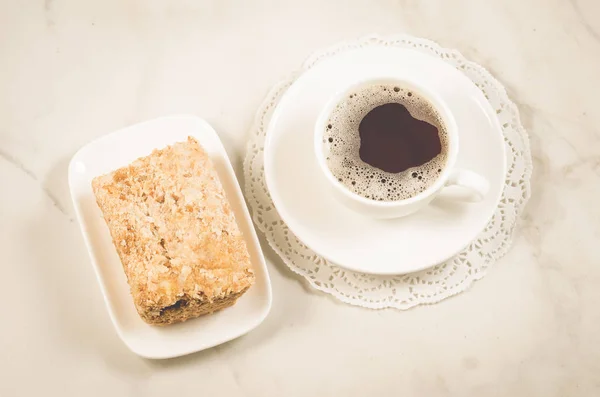 white cup of coffee and dessert/white coffee cup and biscuit on a white marble  background. Top view