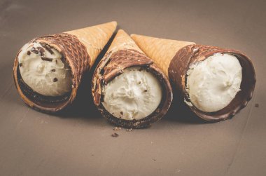 Üç dondurma koni karanlık bir arka plan üzerinde çikolata ile / üç dondurma koni içinde çikolata, seçici odak ile