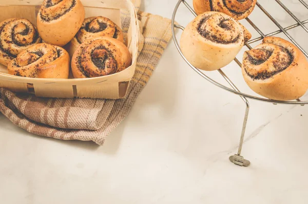 hot rolls with poppy/fresh rolls with poppy on a metal lattice and in a wooden box. Selective focus