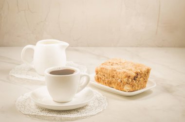 krema, kahve fincanı ve tatlı/krema, kahve fincanı ve tatlı bir wuite üzerinde arka plan mermer. Seçici odak