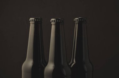 Üç şişe bira karanlık bir arka plan üzerinde / üç şişe bira karanlık bir arka plan, seçici odak üzerinde