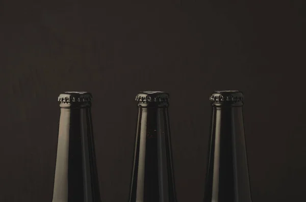 three necks with a stopper of beer bottles/three necks with a stopper of beer bottles on a dark background