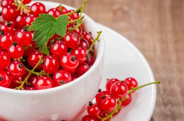 beyaz fincan kırmızı çilek/beyaz Kupası ahşap arka plan üzerinde kırmızı çilek dolu dolu. Yakın çekim