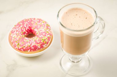 Kahve molası ile taze şekerli pembe çörek üzerinde beyaz mermer zemin ile taze şekerli pembe çörek/kahve arası. 