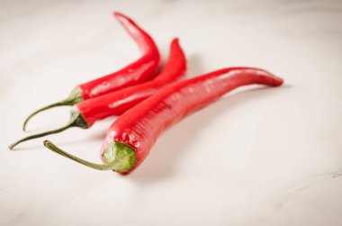 beyaz mermer zemin üzerinde parlayan kırmızı acı biber/kırmızı acı biber. Seçici odak ve boşaltmak