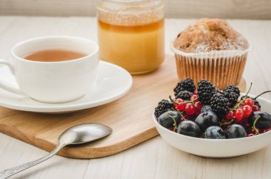 çay taze çilek, pasta ve bal/sağlıklı kahvaltı: çay taze çilek, pasta ve ballı bir ahşap yüzeyde. Seçici focu