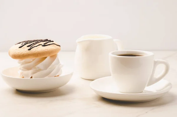Coffe white cup with dessert and milk on white marble background/Coffe white cup with dessert and milk on white marble background. Selective focu