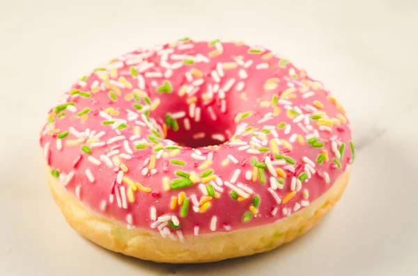 Sweet and colourful pink doughnut/Sweet and colourful pink doughnut on a marble background. Selective focus