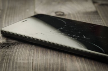 kırılmış cam üzerinde siyah smartphonebroken cam ahşap arka plan üzerinde siyah Smartphone