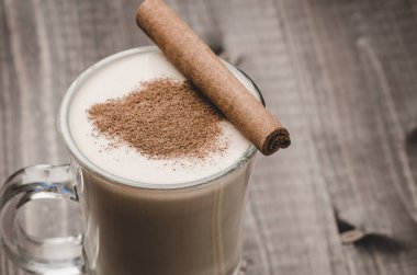 Tarçın/eggnog tarçın ahşap bir zemin üzerine bir bardak bir cam ahşap arka plan üzerinde yumurta likörü. Seçici odak