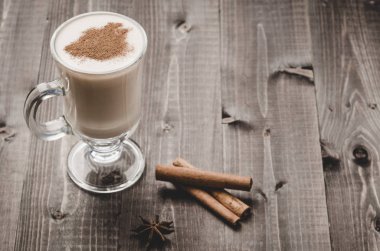 Tarçın/eggnog tarçın ahşap bir zemin üzerine bir bardak bir cam ahşap arka plan üzerinde yumurta likörü. Kopya alanı ile