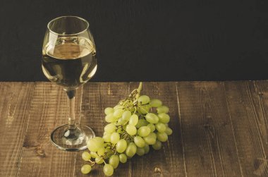 beyaz şarap ve üzüm/bardağı beyaz şarap ve üzüm ahşap bir masa, seçici odak üzerinde