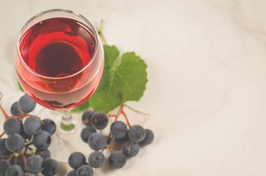 kırmızı şarap, üzüm/bardak, kırmızı şarap ve üzüm beyaz mermer zemin üzerinde. Üstten görünüm