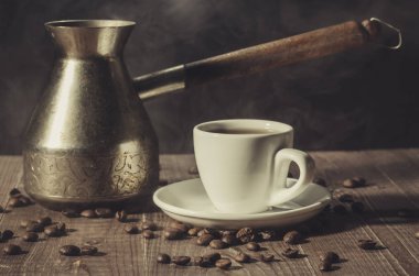 kahve makinesi ve beyaz bir ahşap arka plan/kahve makinesi ve kahve ahşap arka plan üzerinde beyaz fincandan kahve fincandan. Tonda