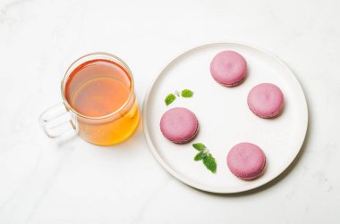 tatlı macaroons veya macaron ile nane yaprakları beyaz bir kase içinde ve 