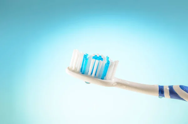 Spazzolino da denti umido su sfondo blu, primo piano — Foto Stock