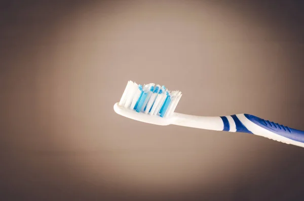 Damp toothbrush on a gray background, close up — Stock Photo, Image