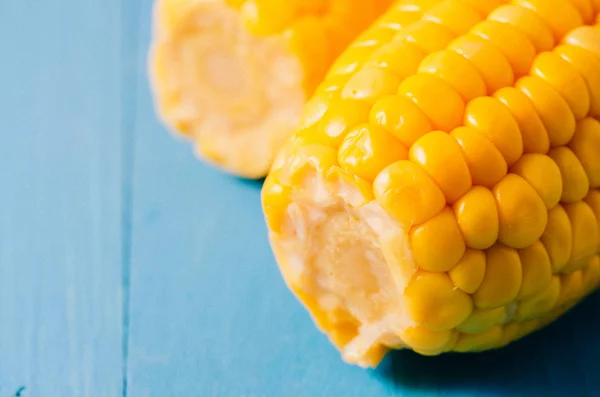 Two ears of boiled appetizing corn on a blue background/Close up — Stock Photo, Image