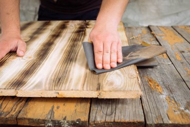 Erkek eller zımpara kağıdı işlerken erkek eller zımpara kağıdı işlerken ahşap işlerken. Karşıt görünüm.