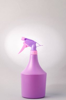 Açık gri arka planda spreyi olan şişe. Gri arkaplanda izole edilmiş mor sprey şişesi.