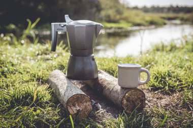 Ormandaki ateşte kahve makinesi, ormandaki ateşte kahve makinesi ve güneşli bir günde kahve fincanı.