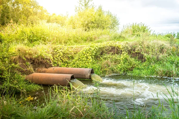 sewage pipes pollute the water/sewage pipes pollute the water in the river. Environmental pollutio