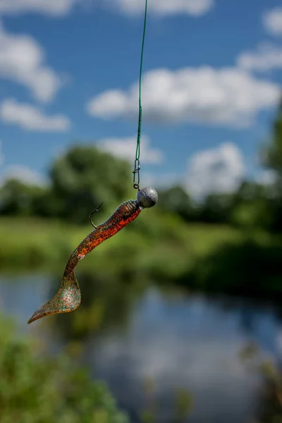 川を背景にした釣り糸の上でのシリコーン釣り餌 シリコーン釣り餌 — ストック写真