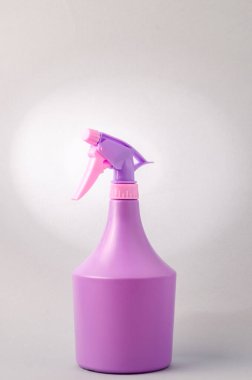 Açık gri arka planda spreyi olan şişe. Gri arkaplanda izole edilmiş mor sprey şişesi.