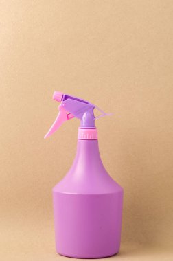 Açık kahverengi arka planda spreyli şişe / açık kahverengi arka planda izole edilmiş mor sprey şişe