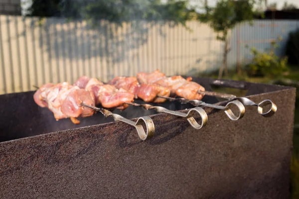 日当たりの良い日に肉を焼くために串刺しにされた肉 — ストック写真