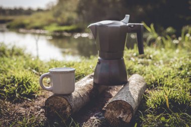 Ormandaki ateşte kahve makinesi, ormandaki ateşte kahve makinesi ve güneşli bir günde kahve fincanı.