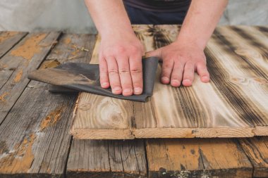 Erkek eller zımpara kağıdı işlerken erkek eller zımpara kağıdı işlerken ahşap işlerken. Karşıt görünüm.