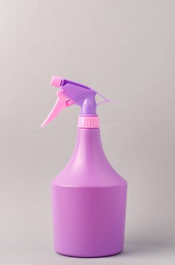 Açık gri arka planda spreyi olan şişe. Gri arkaplanda izole edilmiş mor sprey şişesi.