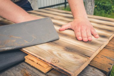 Tahta bir yüzey / insanın eli zımpara kağıdıyla ahşap bir yüzey işliyor.