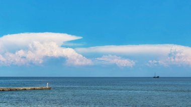 Mavi deniz horizon ve balıkçı iskelede gemide ile bulutlar gökyüzü altında