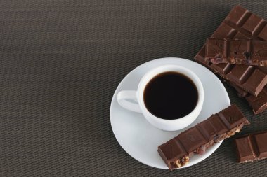 Siyah kahve ve çikolata kahverengi bir arka plan üzerinde beyaz Kupası
