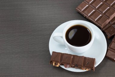 Siyah kahve ve çikolata kahverengi bir arka plan üzerinde beyaz Kupası
