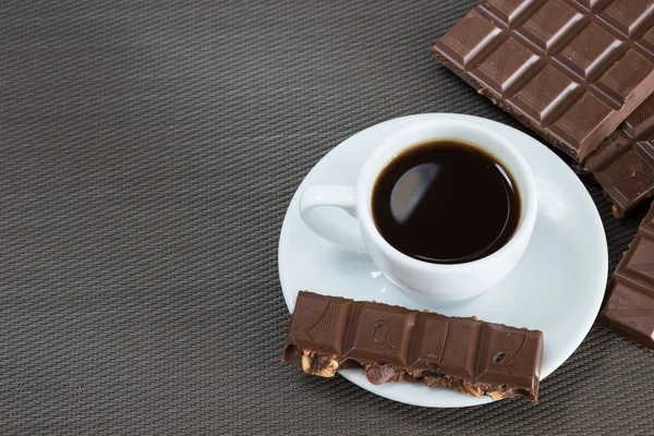 Siyah kahve ve çikolata kahverengi bir arka plan üzerinde beyaz Kupası