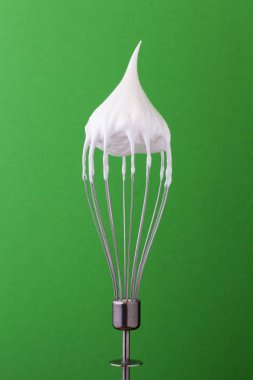 Metal çırpma teli ile yeşil zemin üzerine çırpılmış yumurta akı