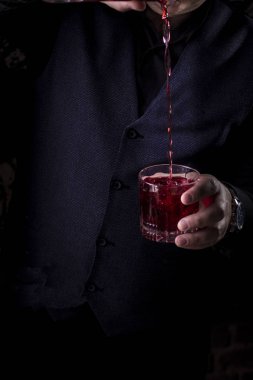 Barmen bir bar ferahlatıcı kokteyl yapmak arka plan. Karanlık moody tarzı. Cam buz